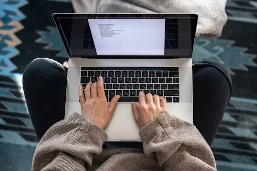 intelligenza-artificiale-tesi-universita-scrittura Studente universitario scrive un elaborato al computer usando l'intelligenza artificiale